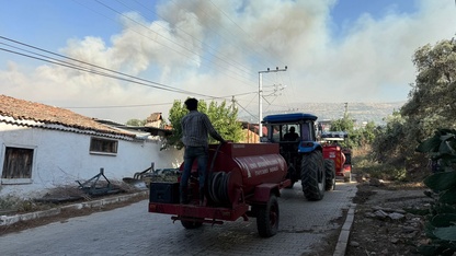 İzmir'de otluk alandan yerleşim yerlerine sıçrayan yangın söndürülmeye çalışılıyor